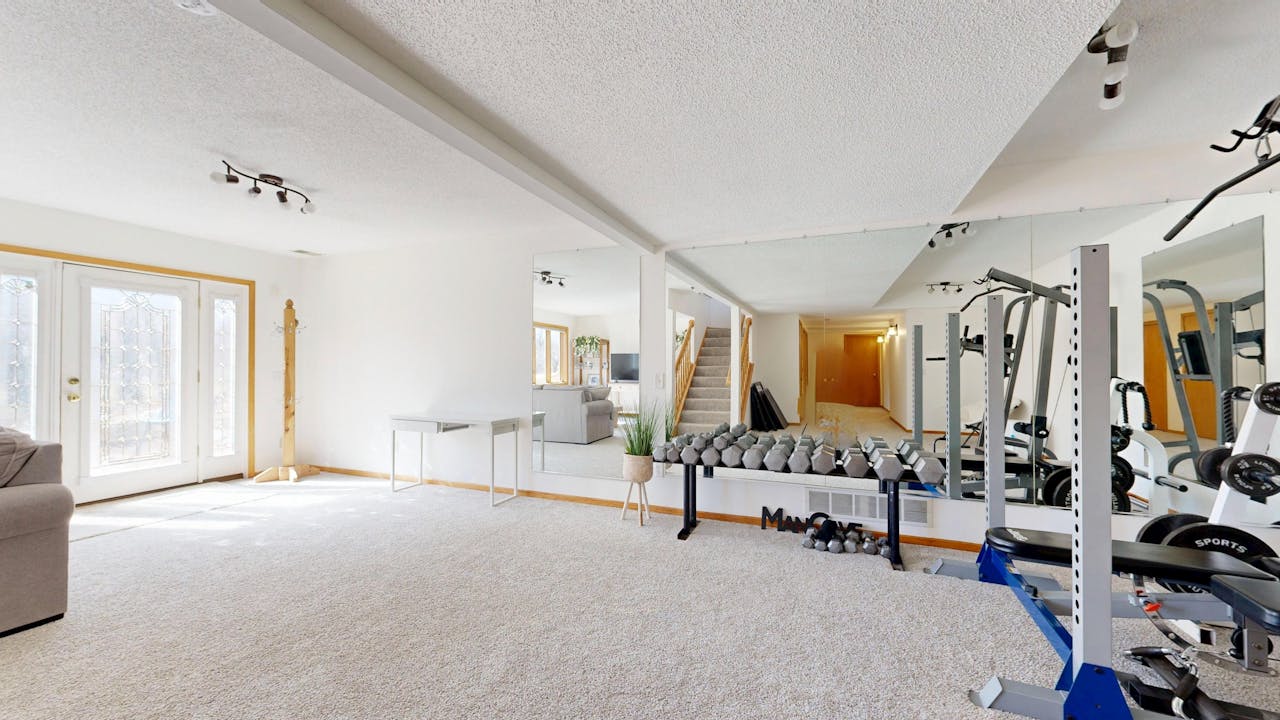 Bright home gym setup with weights, mirrors, and modern decor.